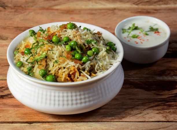 Traditional hyderabadi Vegetable / veg dum biryani with mixed veggies served with mixed raita, selective focus